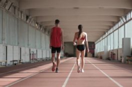 Fit professional athletes walking along running track
