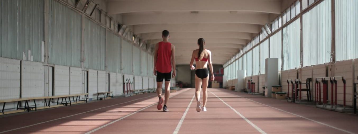 Fit professional athletes walking along running track