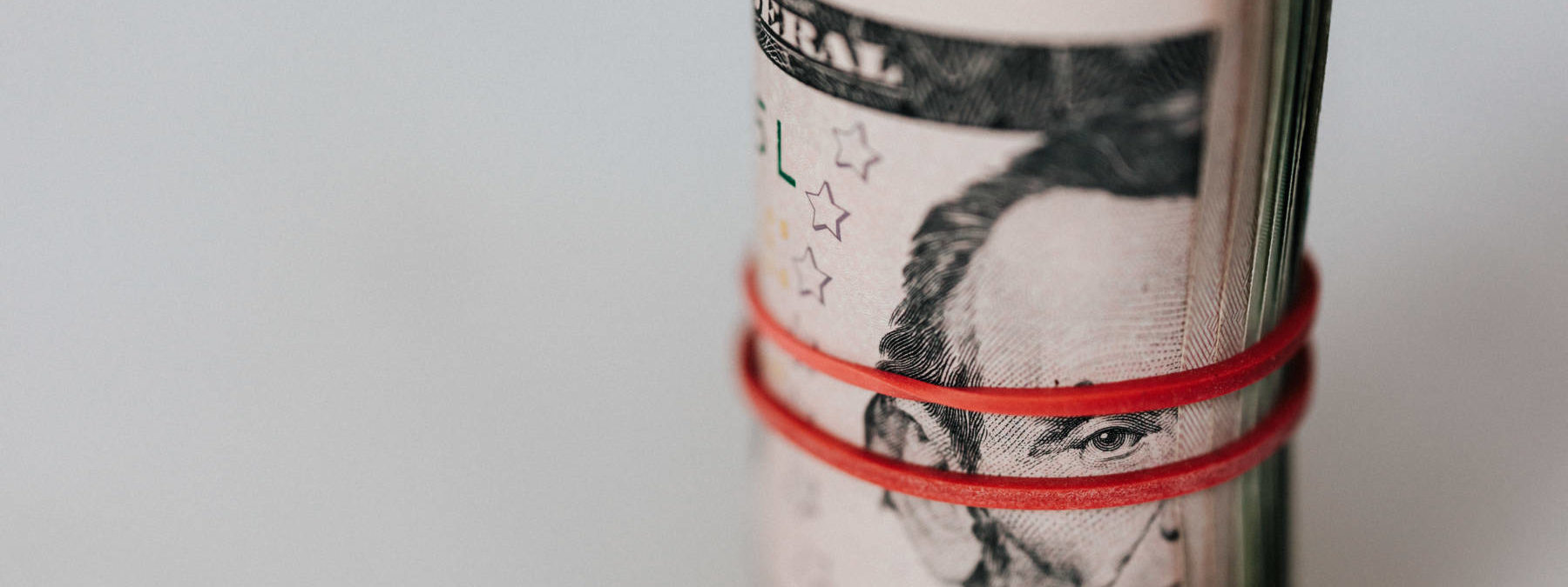 Roll of american dollars tightened with red band